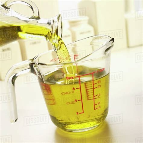 Pouring Olive Oil Into A Glass Measuring Cup Stock Photo Dissolve