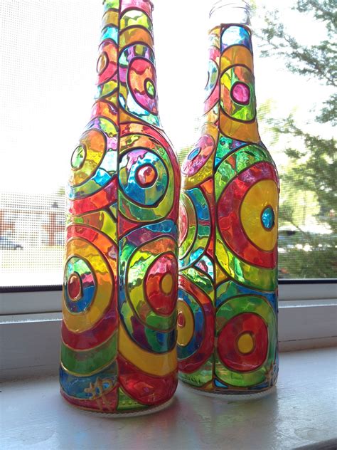 Two Colorful Bottles Sitting On Top Of A Window Sill