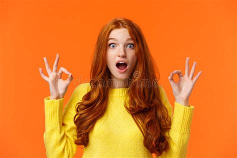 astonished and impressed surprised redhead curly woman with blue eyes freckles rate something