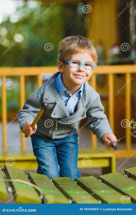 Close Up Portrait Of Cute Boy Playing Xylophone Outdoor Stock Image