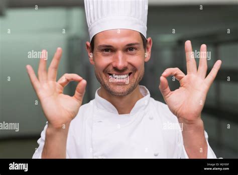 Happy Chef Making Ok Sign To Camera In A Commercial Kitchen Stock Photo