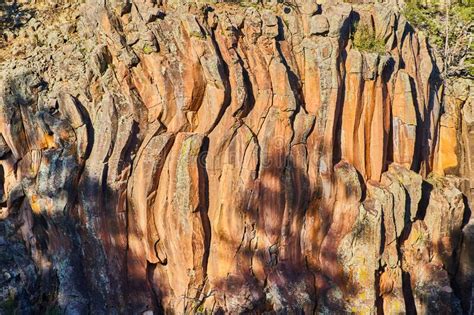 Detail Of Cliff With Wavy Vertical Rock Formations In Golden Light