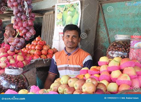 Asian Fruit Seller Sitting At His Stall And Waiting For Customers