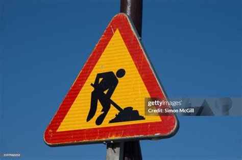 Road Work Ahead Traffic Warning Sign Against A Clear Blue Sky High Res