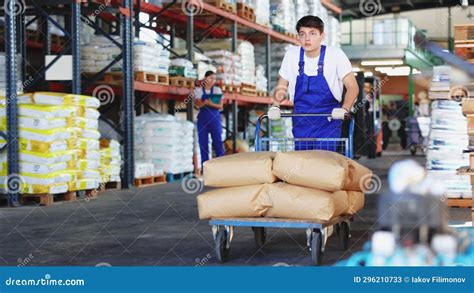 Guy Worker Carries Pushes Cart Trolley for Cargo Transportation. Stock