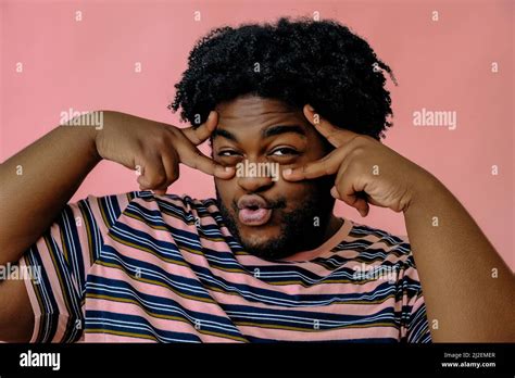 Young Happy African American Man Posing In The Studio Over Pink