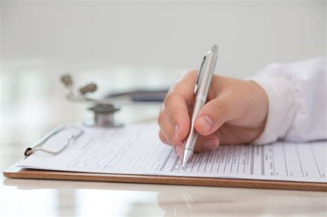 Free Photo Doctor Filling Out A Medical Form