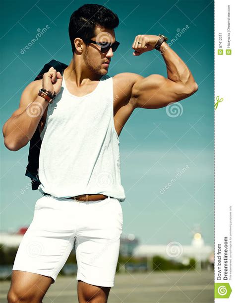 Andsome Muscled Model Man In Casual Cloth In Sunglasses In The Street Showing His Muscles Stock
