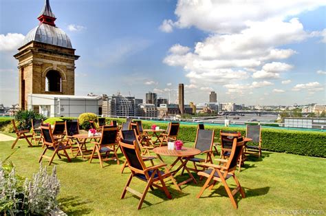 There Are Many Wooden Chairs And Tables On The Grass Field With