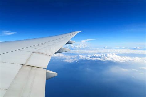 Aerial View Of Plane Window Above Clouds Under Blue Sky View From