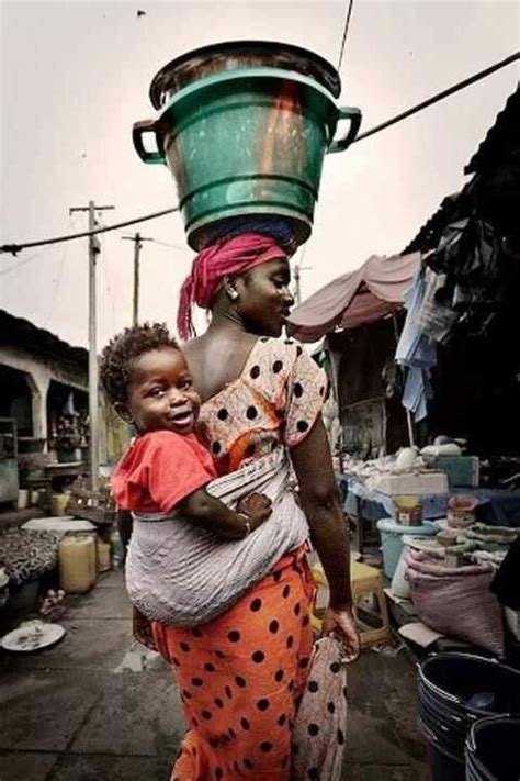 east africa mother carrying green bucket on her head to market african people african women
