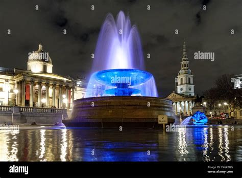 Illuminated Fountain At Trafalgar Square At Night London England