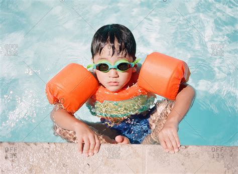 Little Boy Wearing Floaties On The Edge Of A Pool Stock Photo Offset