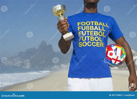 Champion Brazilian Football Player Holding Trophy And Football Stock