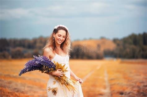 Dziewczyna Z Bukietem Stokrotki I Cornflowers W Polu Zdjęcie Stock