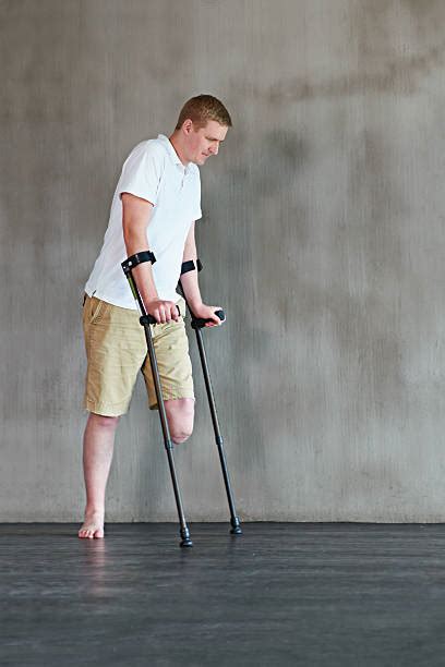 Handicapped One Legged Man Walking On Crutches Stock Photos Pictures