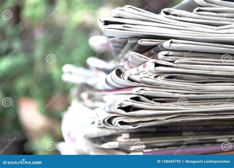 Newspapers Folded And Stacked On The Table With Outdoor Garden Or Green
