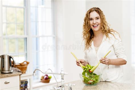 smiling woman tossing salad in kitchen stock image image of middleaged adult 29678115