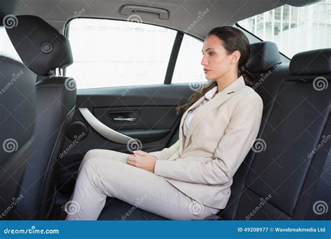 Unsmiling Businesswoman Sitting In The Back Seat Stock Image Image Of
