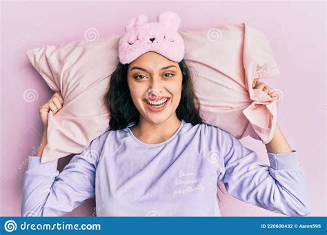 beautiful middle eastern woman wearing sleep mask and pajama sleeping on pillow smiling and