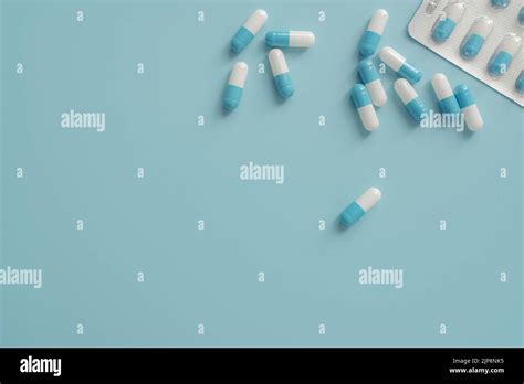 Antibiotic capsule pills on blue background. Prescription drugs. Blue