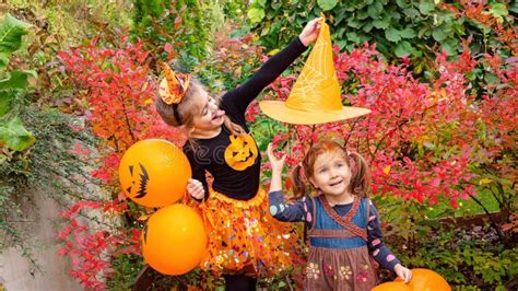 Children In Halloween Carnival Costumes Two Sisters Rejoice And Laugh