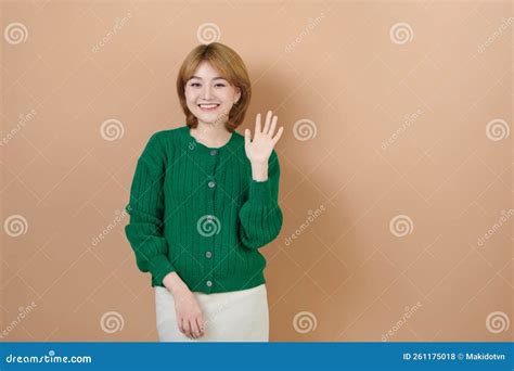 Smiling Woman Raised Her Hand Palm Up And Forward Like Waving Stock