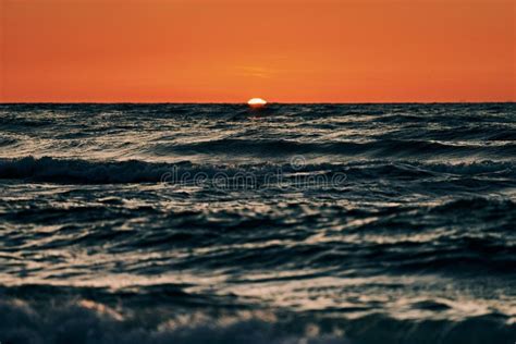 Half Sun Below Horizon Over Blue Sea Waves Beautiful Sunset Over Sea