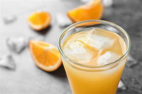 Glass Of Orange Juice With Ice Cubes On Table Closeup Stock Photo