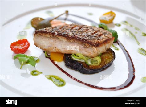 Steamed Stone Bass With Aubergine Courgette Peppers Black Olive Oil And Pesto Served At Coq D