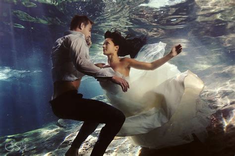 A Bride And Groom Are Underwater In Their Wedding Dress