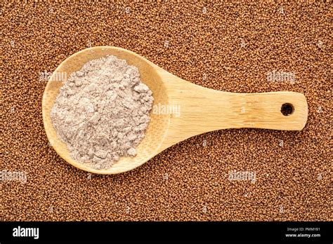 Gluten Free Brown Teff Grain And Flour Wooden Spoon Against Seed
