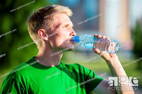 Tired Man Drinking Water From A Plastic Bottle After Fitness Time And
