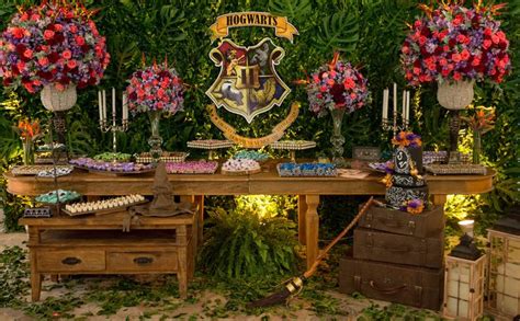 A Harry Potter Themed Dessert Table With Flowers And Candles On It