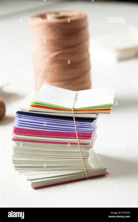 Closeup Of Stacked Papers And Thread On Table In Factory Stock Photo