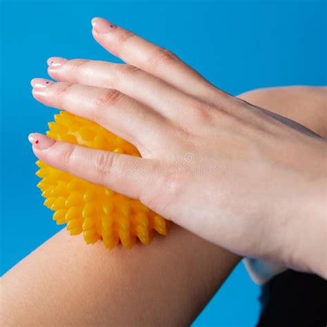Female Hand Holds A Yellow Massage Ball Massages The Forearm Close Up