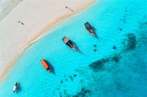 Aerial View Of The Fishing Boats In Clear Blue Water At Sunset Stock