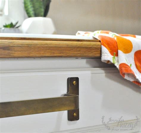 This design is very simple, where the oven door handle under the sink is used to put towels. Brass towel bar under sink - Jennifer Rizzo