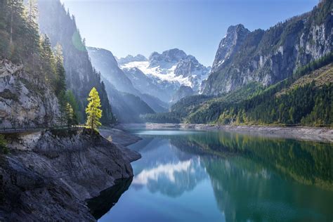 A Lake Surrounded By Mountains And Trees In The Middle Of Its Own Area