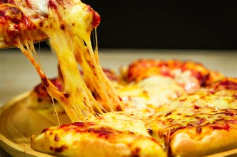 Fatia De Pizza Quente Com Queijo Derretendo Sobre Uma Mesa Foto Premium