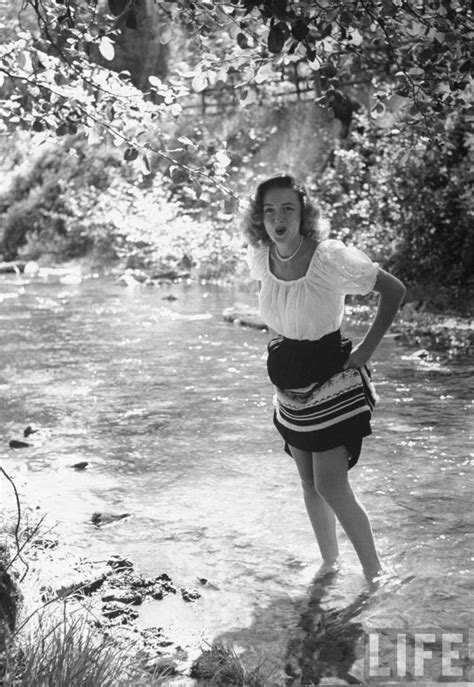 a woman standing in the water with her hands on her hips