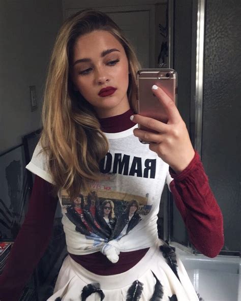A Woman Taking A Selfie In Front Of A Mirror Wearing A Skirt And T Shirt