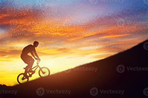 Man Riding A Bmx Bike Uphill Against Sunset Sky Strength Challenge