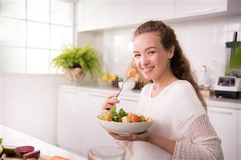 Mujer Sana Que Come La Ensalada En La Cocina Imagen De Archivo Imagen