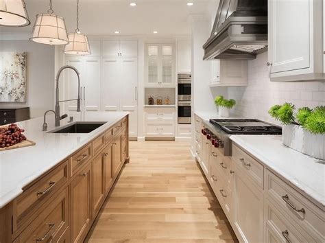 Ej interiors installed white cabinetry and marble countertops to create a cooking space that feels bright and polished. Two toned Kitchen island featuring oak cabinetry and white ...
