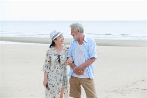 portrait asia senior woman and caucasian old man relaxing together on the beach stock image