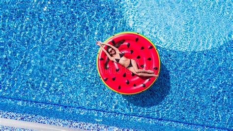aerial view of female in bikini lying on a floating mattress in swimming pool summer vacation