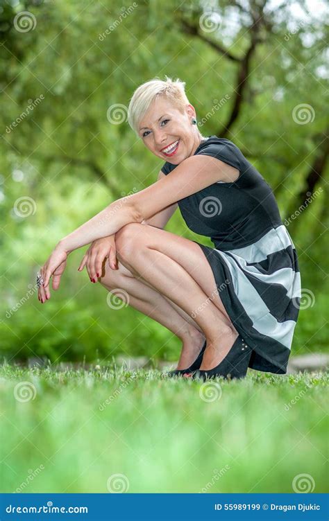 Attractive Blonde Girl Posing In Nature Crouching Stock Image Image