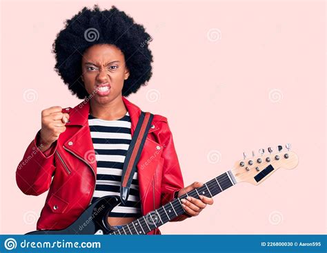 Young African American Woman Playing Electric Guitar Annoyed And