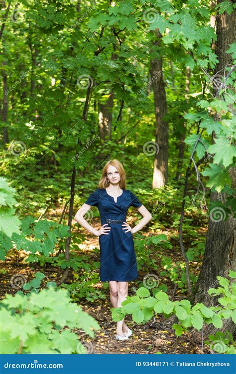 Beautiful Woman In Elegant Dress And Charming Smile Posing In The Park